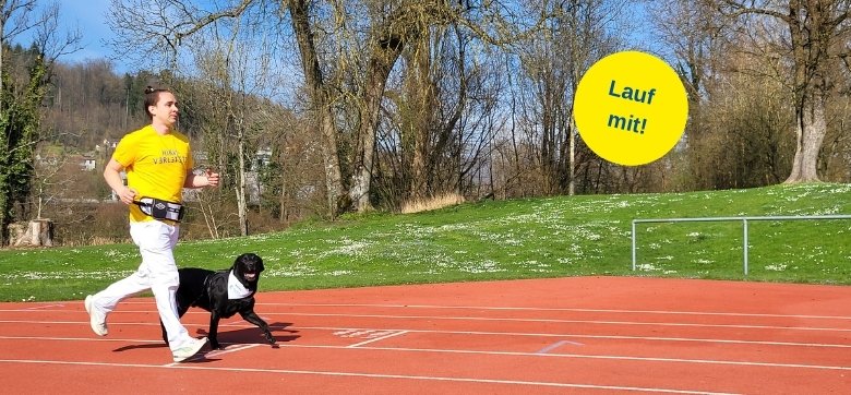 Ein junger Mann mit gelbem T-Shirt und weisser Hose läuft auf einer Laufbahn. Neben ihm läuft ein schwarzer Labrador mit. Text im Bild: Lauf mit!