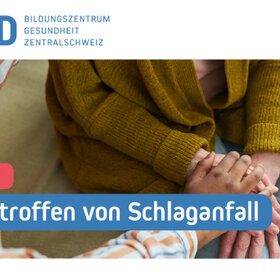 Eine sitzende Person hat beide Hände auf ihrem Oberschenkel übereinandergelegt. Eine zweite Person legt ihre Hand darüber. Zuoberst das Logo von XUND: Bildungszentrum Gesundheit Zentralschweiz. Am unteren Bildrand der Text: Seminar. Mitbetroffen von Schlaganfall