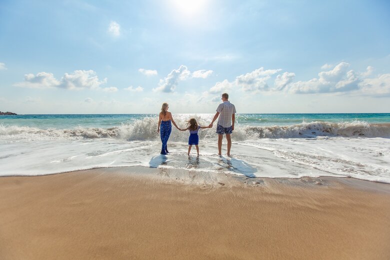 Une famille sur une plage, les pieds dans l'eau