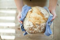 Une personne tient une miche de pain