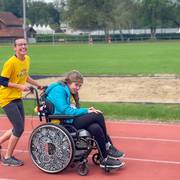 Eine Teilnehmerin im Rollstuhl wird von einer weiteren Läuferin gestossen.
