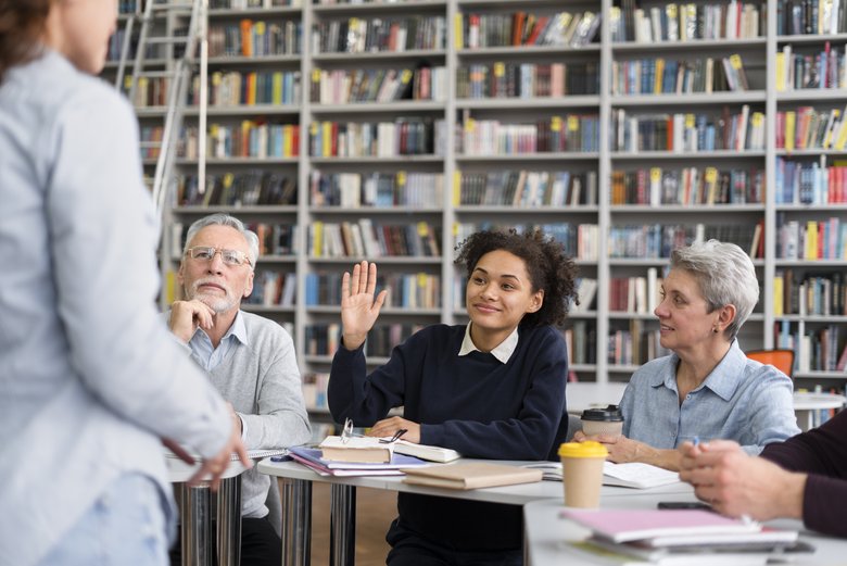 Cours Plusieurs personnes suivent un cours, une participante lève la main