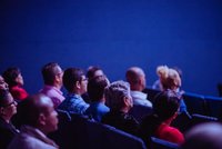 Des personnes assises dans le public dans une salle de conférence