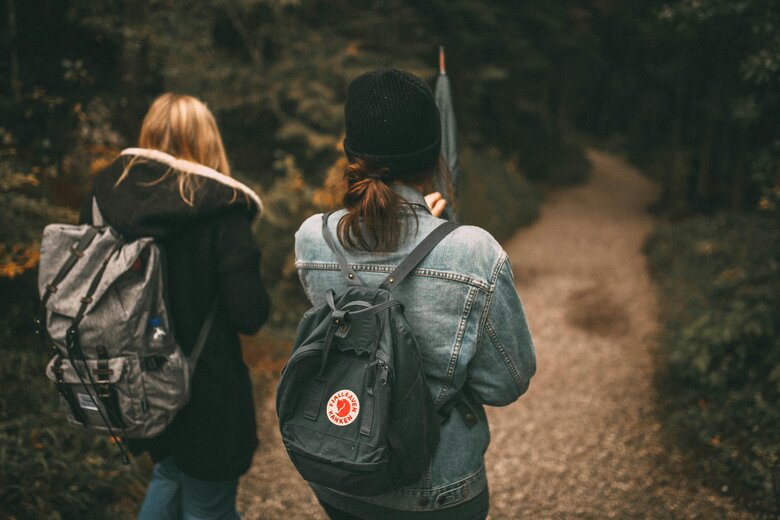 Réadaptation plus longue Deux femmes de dos marchant en forêt