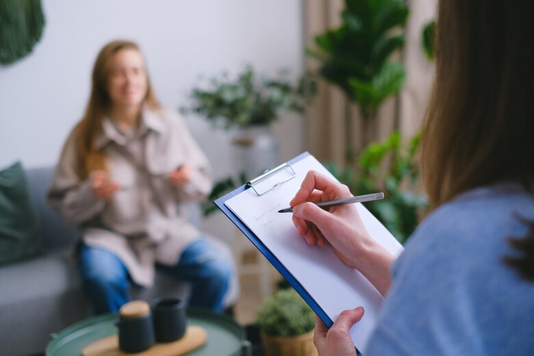 Une personne prenant des notes pendant qu'une autre personne parle