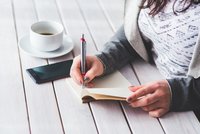 Une femme écrivant sur un bloc-notes