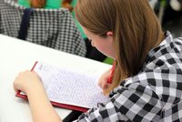 Une jeune fille écrit sur une feuille