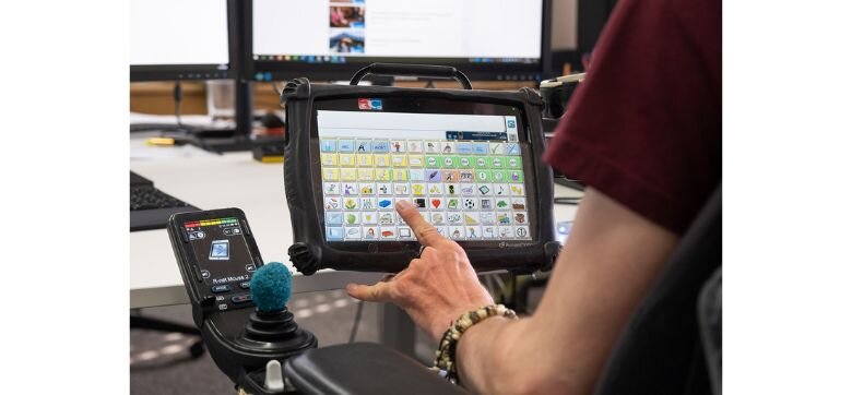 Hilfsmittel mit Symbolen Eine Person berührt einen Bildschirm mit Symbolen.