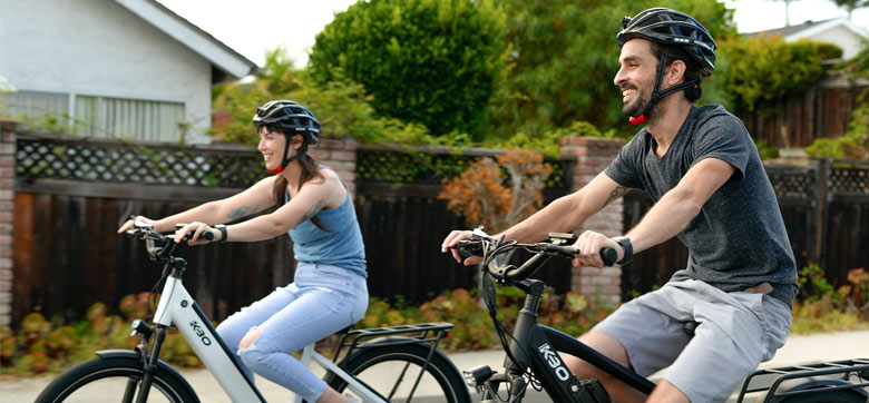 Une femme et un homme font du vélo. Ils portent un casque.
