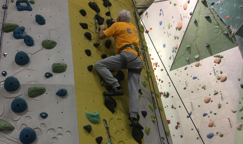 Ein Mann klettert an einer Kletterwand