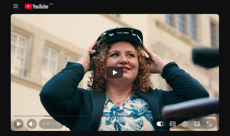 Screenshot eines Youtube-Videos. Im Standbild setzt Stefanie F. einen Velohelm auf.